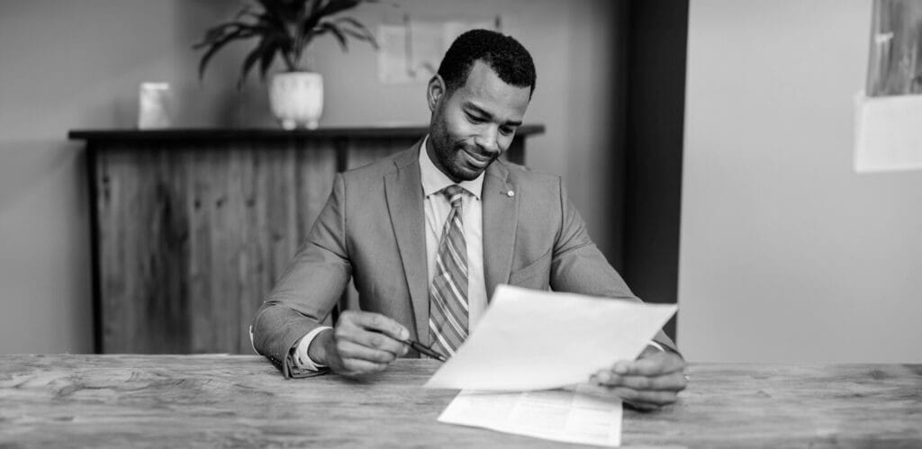 A man sits at a desk, reviewing papers, learning: What is commercial insurance?