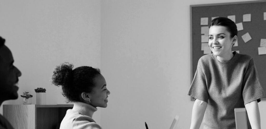 woman standing in front of bulletin board leading meeting about broker marketing