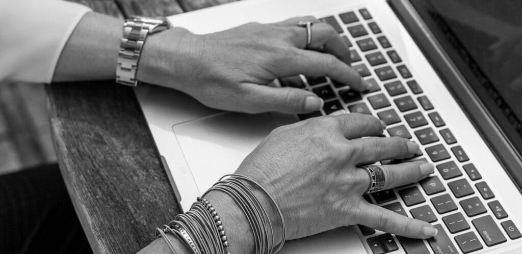close up of hands typing on a keyboard