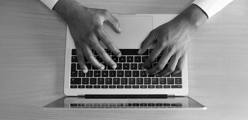 Close-up image of hands on a laptop keyboard, shot from above