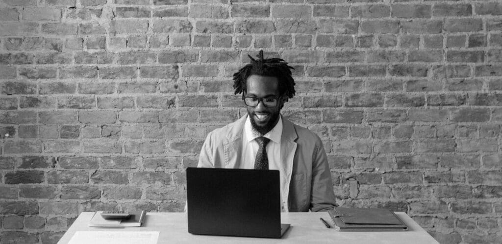 Smiling seated man working on a laptop